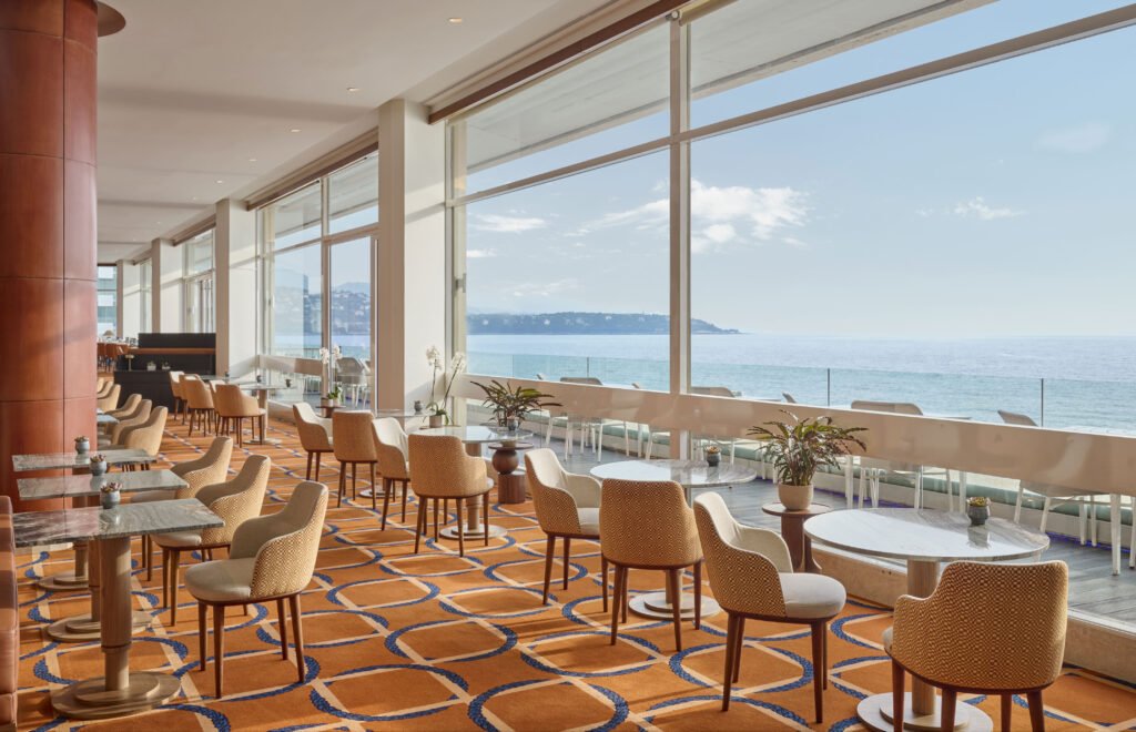Lounge bar du Fairmont Monte Carlo, à Monaco, avec chaises et tables sur mesure Crossline Furniture et vue sur la Méditerranée
